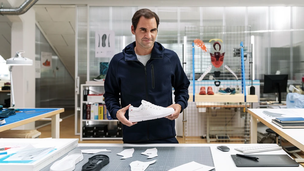 Roger Federer hält einen Schuh der Marke On in einem Produktionsraum
