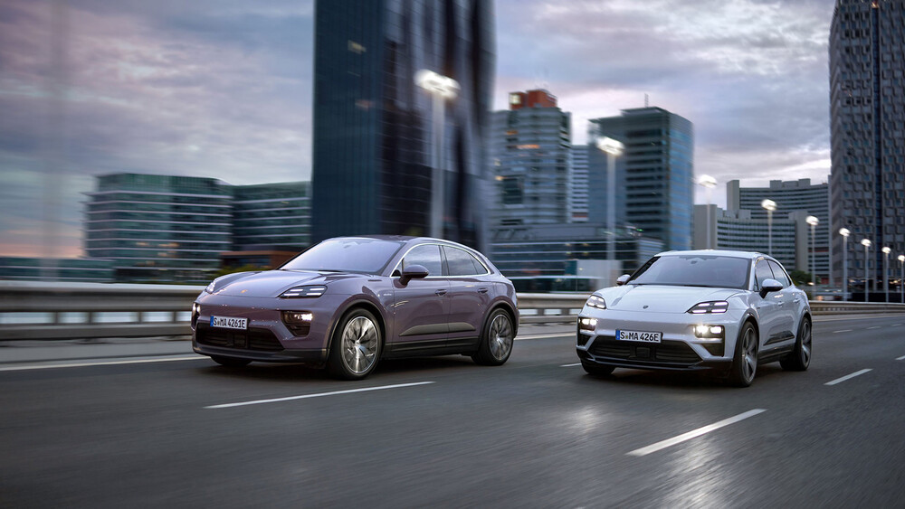 Der neue Porsche Macan 4 und der Porsche Macan Turbo fahren auf einer Schnellstraße aus der City