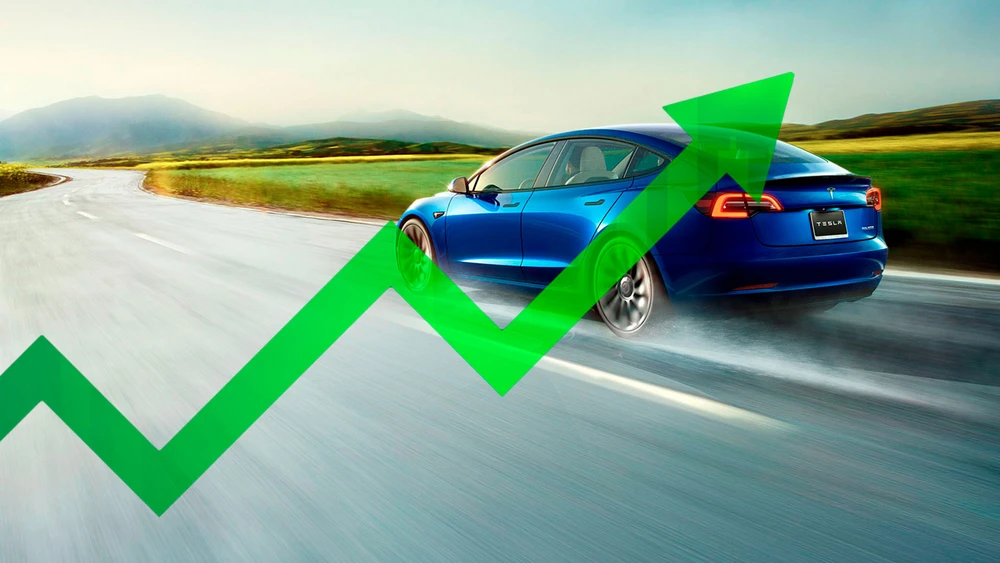 Blaues Tesla Modell fährt auf der Straße vom Betrachter weg vor grünem Pfeil nach oben