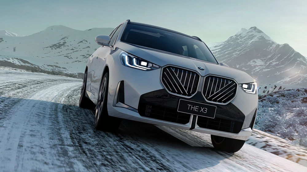 Der neue BMW X3 fährt auf schneebedeckter Fahrbahn in den Bergen