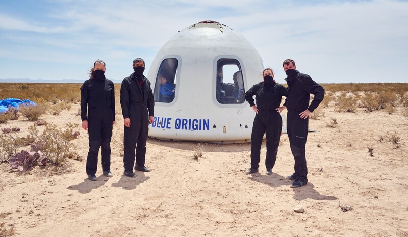 Vier Test-Raumfahrer posieren in der Wüste von Texas neben der gelandeten Raumkapsel.