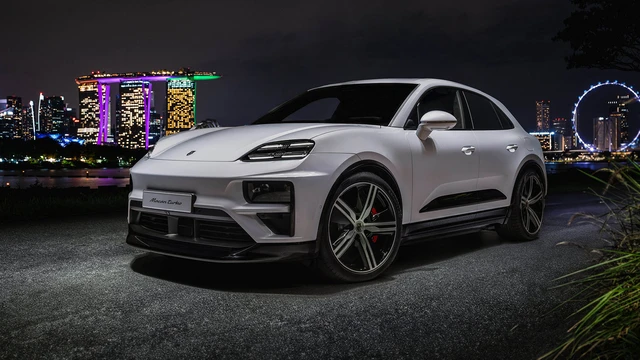 Porsche Macan Turbo steht bei Nacht in der City von Singapur