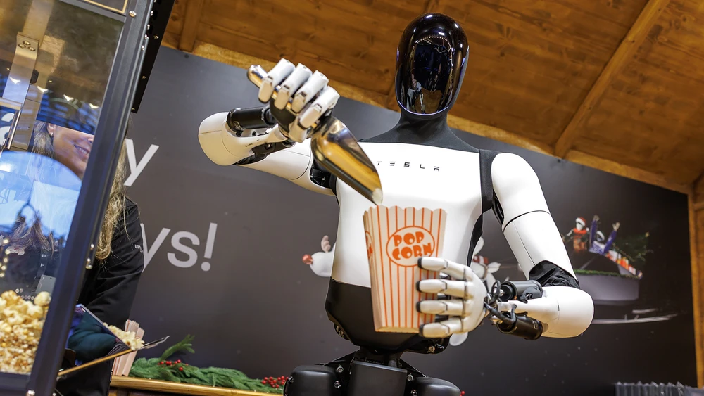 Der humanoide Roboter Optimus von Tesla verteilt an einem Weihnachtsmarktstand Popcorn.