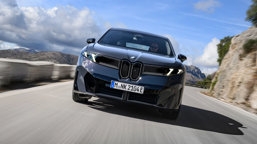 Der neue BMW iX3 fährt auf einer Bergstraße, Frontalansicht