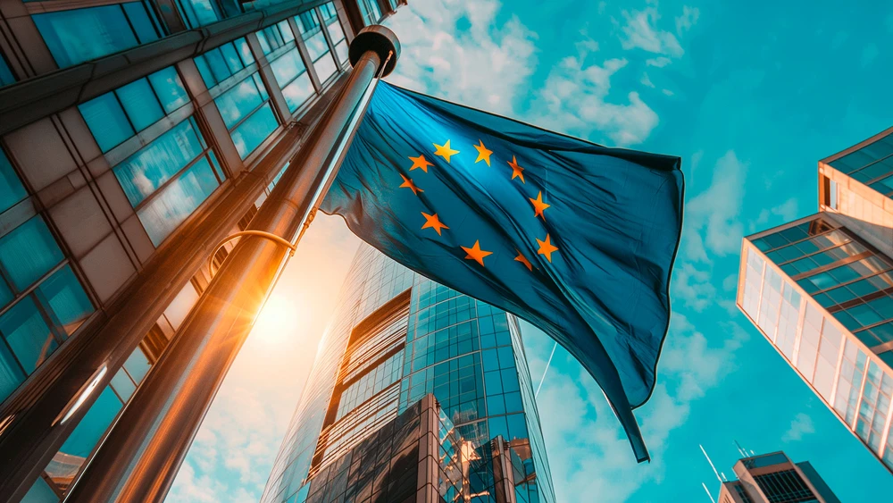 Blick von unten auf EU-Flagge vor Wolkenkratzern